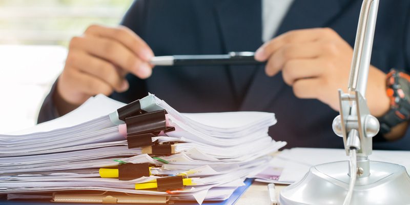 An Investigative analyst with paperwork on a desk