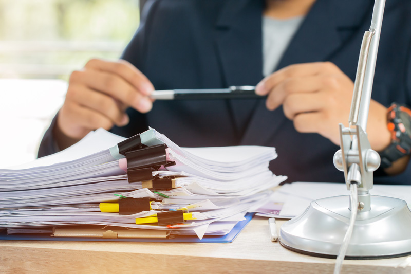 An Investigative analyst with paperwork on a desk